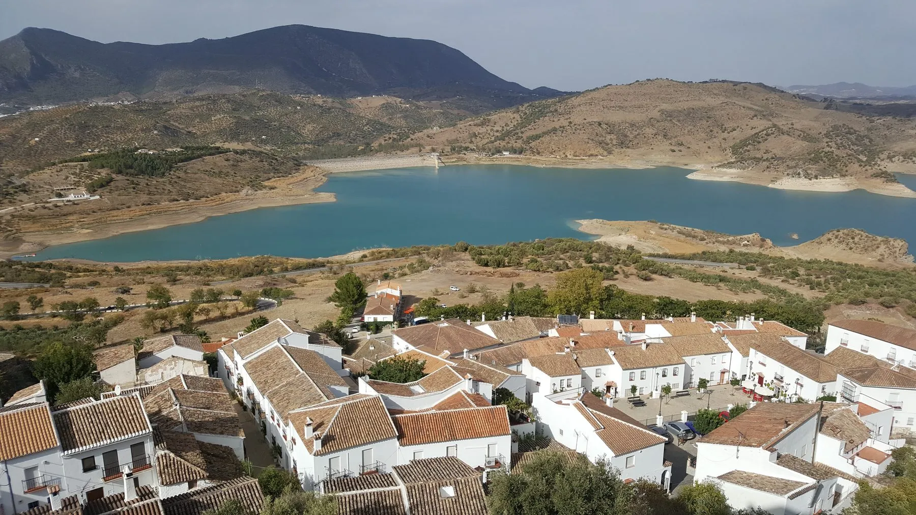 Vista aérea de un pueblo junto a un embalse entre montañas