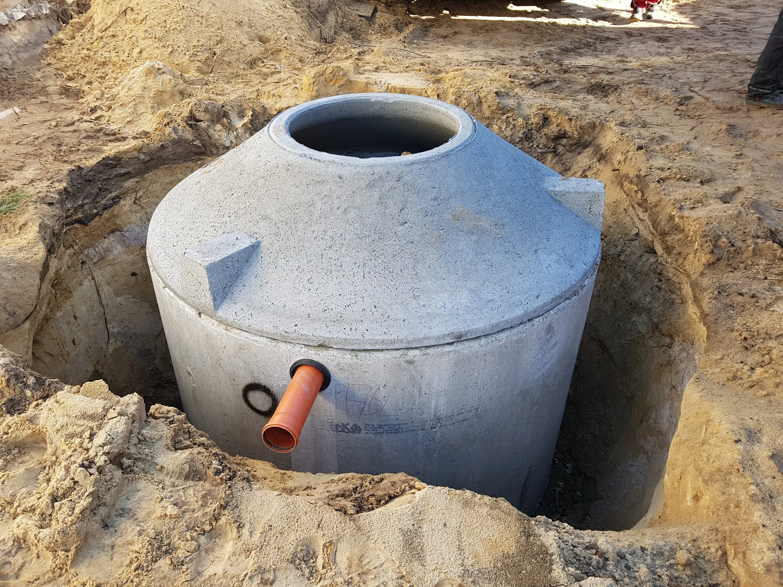 Estanque de hormigón STABI-KOM instalado en la excavación con tubería de salida